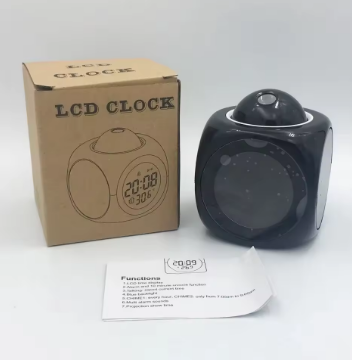 Black LCD clock with packaging and manual on a white background