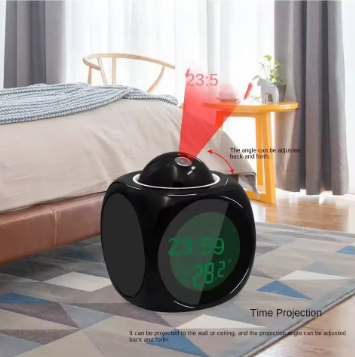 Black digital clock with time projection feature on a bedroom floor.