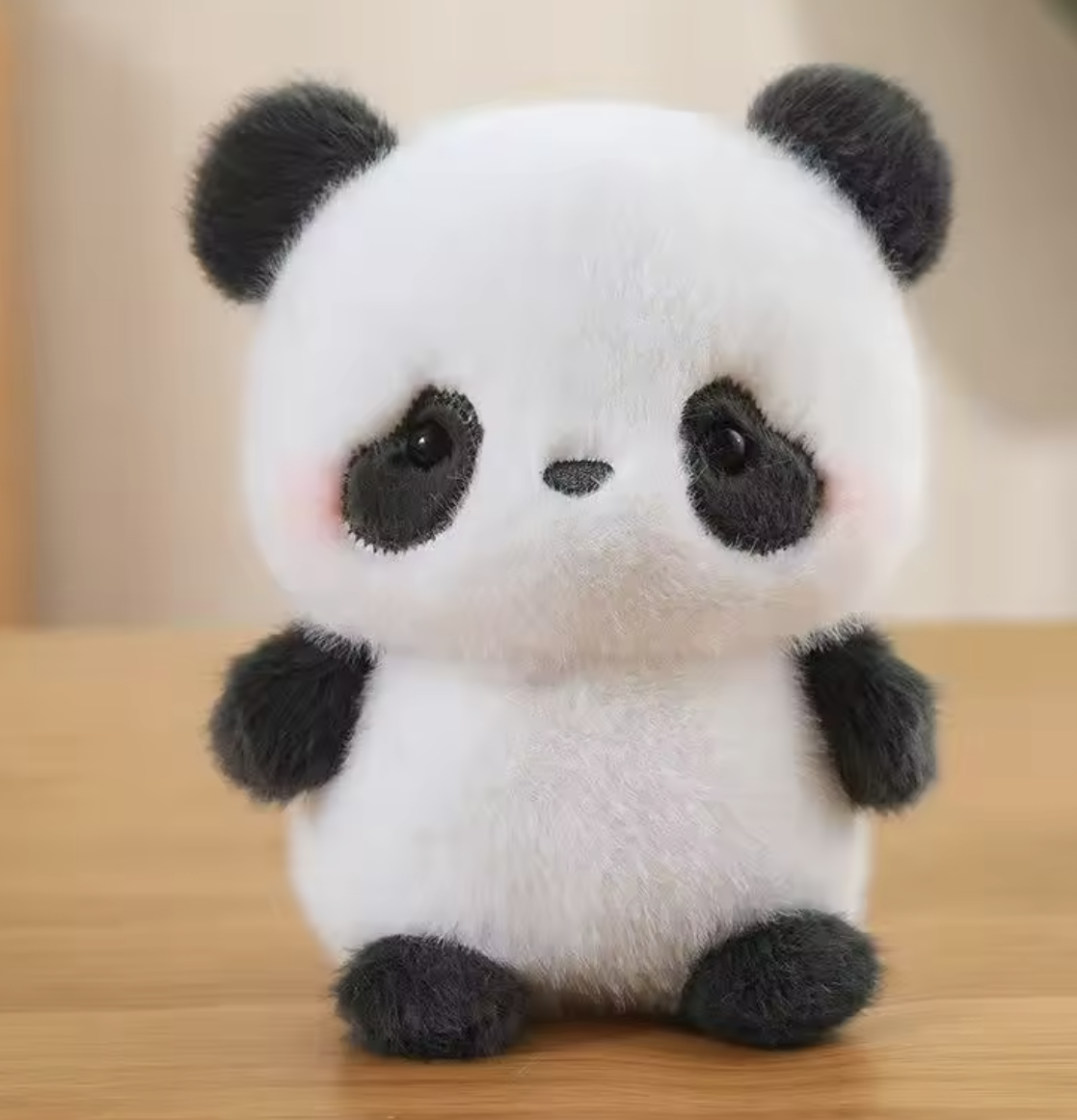 Plush panda toy on a wooden surface with a neutral background
