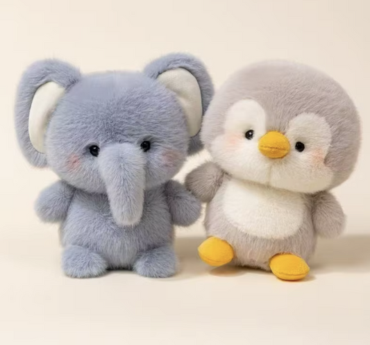Plush toy elephant and penguin on a light background

