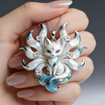 Silver fox pendant with floral details held in a hand against a dark background