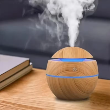 Wooden diffuser emitting steam on a wooden surface with a blurred background